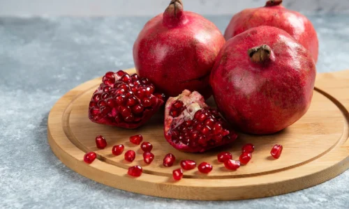 sliced-ripe-pomegranate-wooden-board_114579-55513